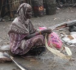 Village woman weaving thin strips for matting, Djibouti